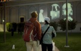 Onlookers at dusk contemplate the 9/11 memorial. 
